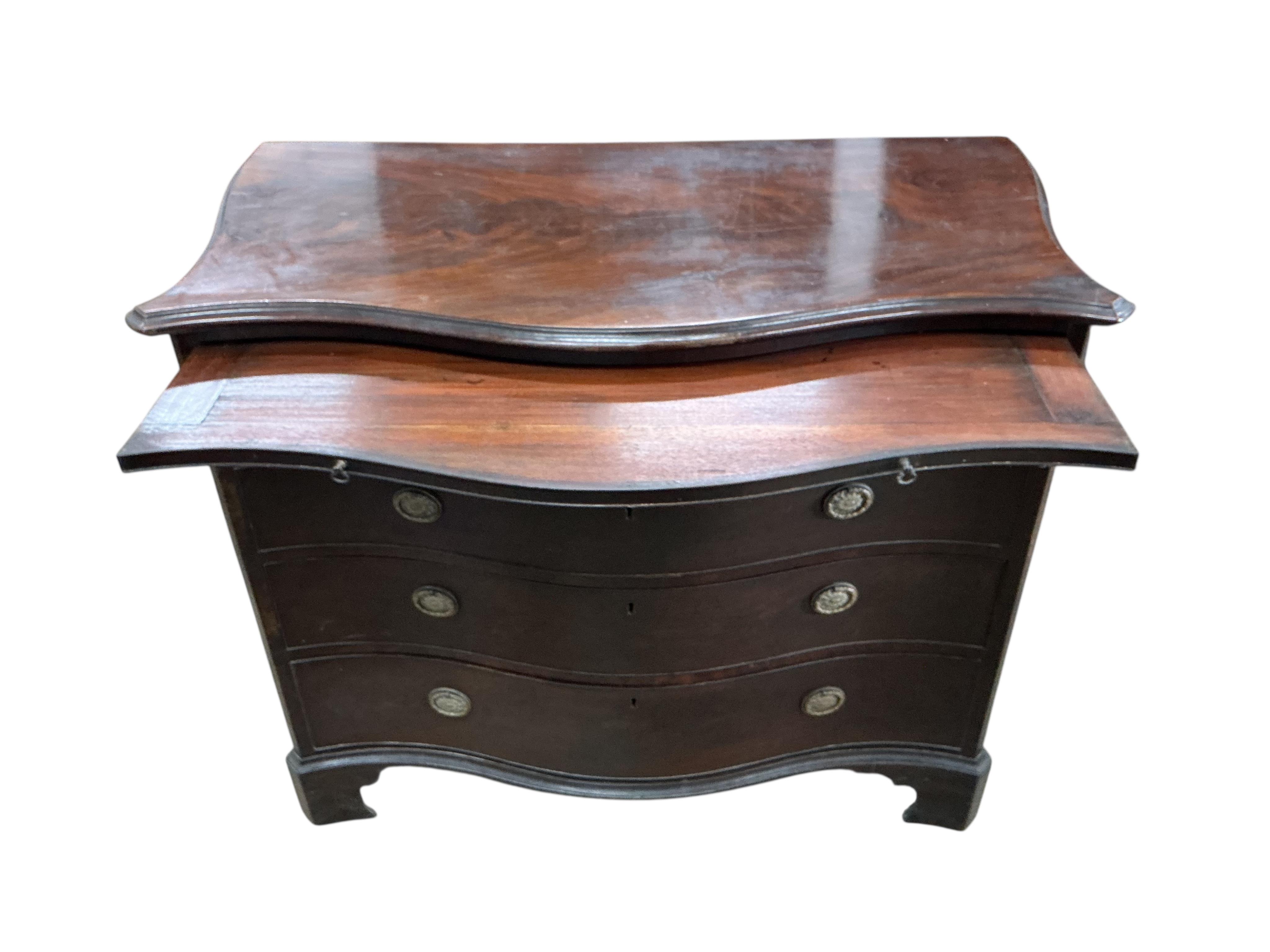 A George III mahogany serpentine chest, with brushing slide, width 111cm, depth 57cm, height 93cm